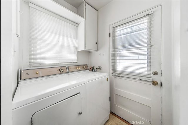 laundry room featuring plenty of natural light, cabinet space, and washer and clothes dryer