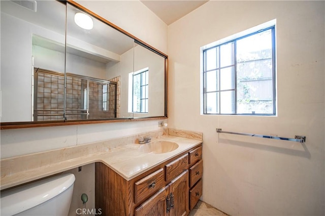 bathroom featuring vanity, visible vents, a tile shower, and toilet