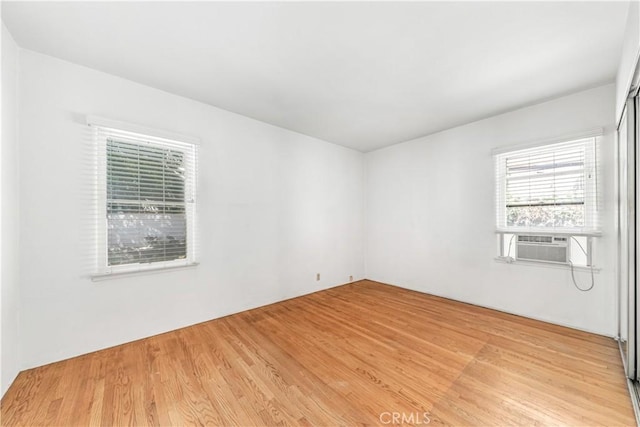 empty room with cooling unit and light wood finished floors