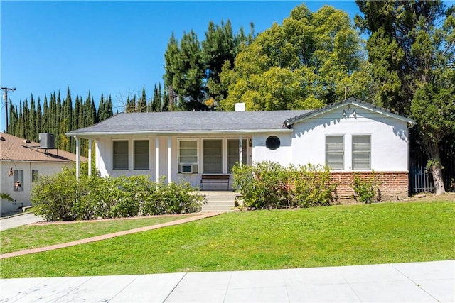 single story home featuring a front yard, central AC unit, a chimney, stucco siding, and brick siding
