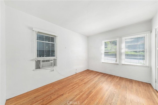 spare room with cooling unit and wood finished floors