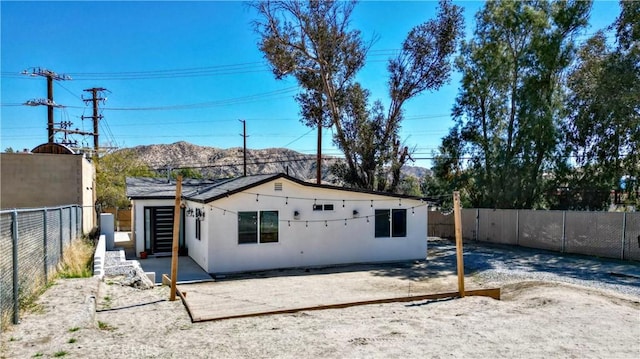rear view of property featuring stucco siding, a patio, and a fenced backyard