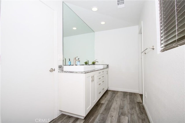 bathroom featuring visible vents, baseboards, recessed lighting, wood finished floors, and vanity