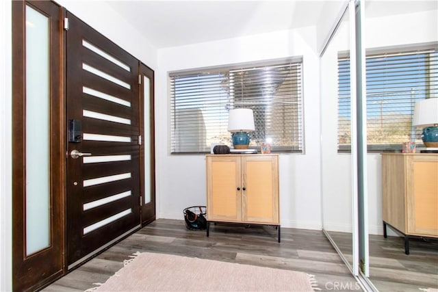 foyer entrance featuring baseboards and wood finished floors