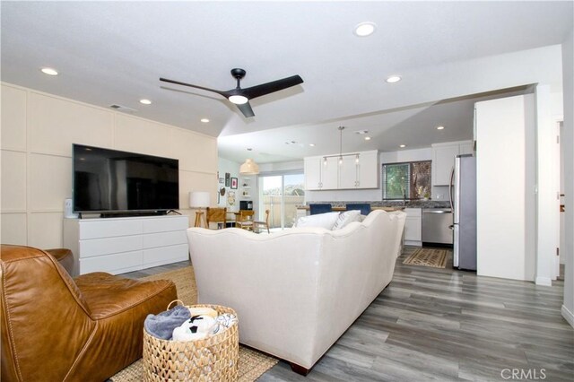 living room with recessed lighting, lofted ceiling, wood finished floors, and a ceiling fan