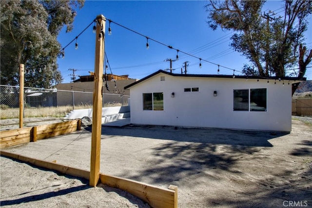 back of house featuring a patio area, fence, and stucco siding