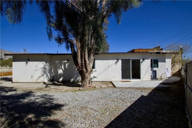 back of house with a patio area, fence, and stucco siding