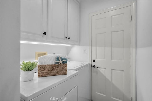 laundry room featuring washing machine and clothes dryer and cabinet space