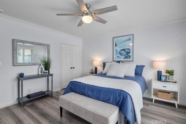 bedroom featuring wood finished floors, crown molding, and baseboards