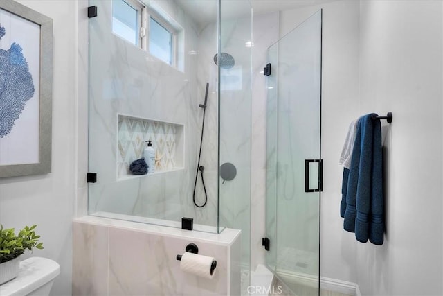 full bathroom featuring a marble finish shower and toilet