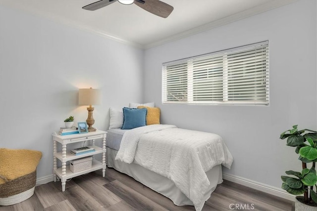 bedroom with baseboards, a ceiling fan, wood finished floors, and ornamental molding