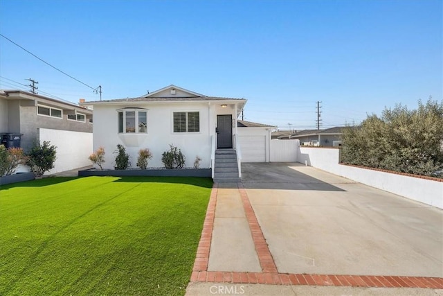 view of front of house featuring stucco siding, driveway, fence, and a front yard