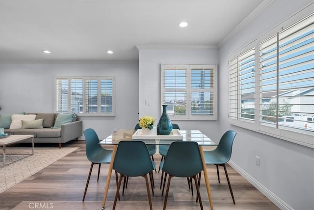 dining area with a wealth of natural light, ornamental molding, and wood finished floors
