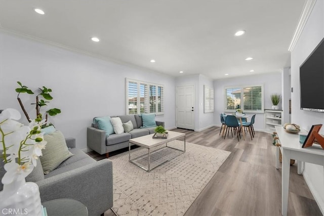 living area featuring recessed lighting, wood finished floors, and crown molding