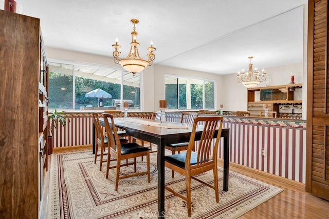 dining room with wood finished floors and an inviting chandelier