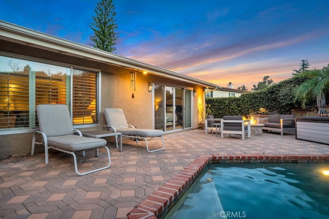 view of patio featuring a fenced in pool and an outdoor living space with a fire pit