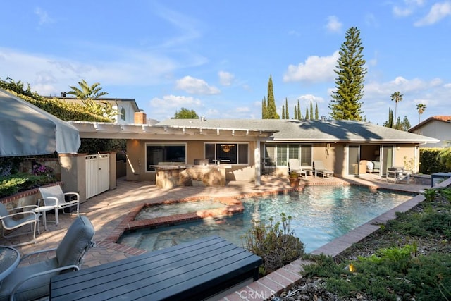 back of house featuring a patio, an outdoor pool, stucco siding, and an outdoor kitchen