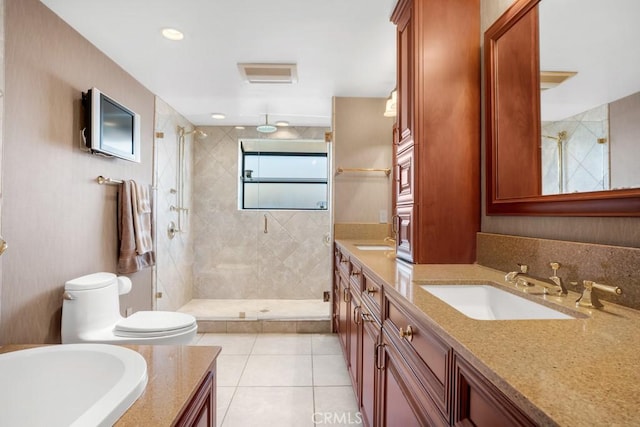 bathroom featuring toilet, a stall shower, double vanity, and a sink