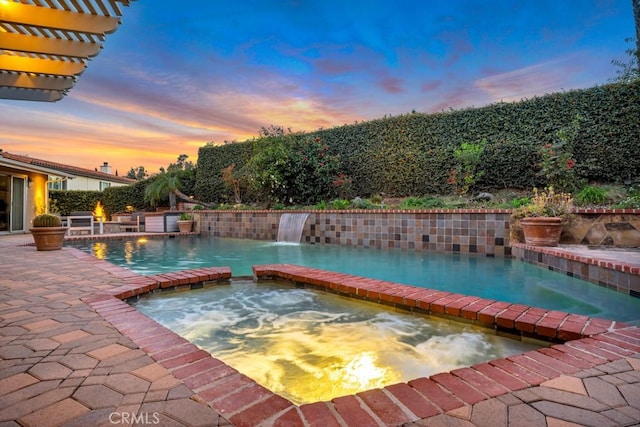 view of pool with a pool with connected hot tub, a patio area, and a fenced backyard