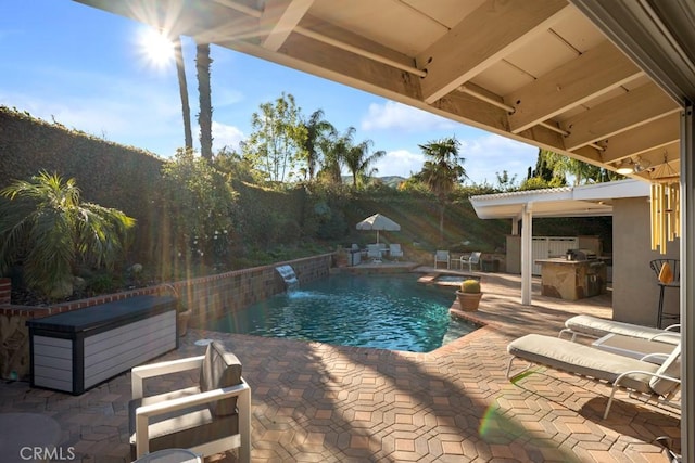 view of swimming pool with a patio area, a pool with connected hot tub, and an outdoor kitchen