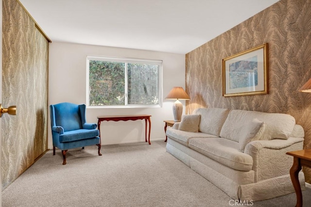 living area featuring wallpapered walls, baseboards, and carpet