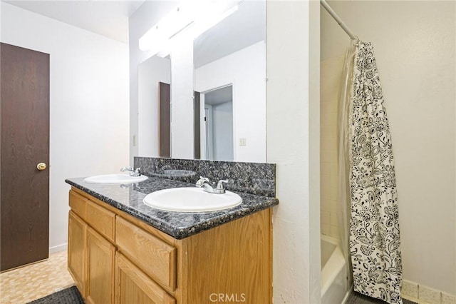 bathroom with shower / tub combo, a sink, and double vanity