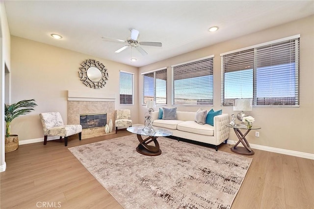 4224 Castlepeak Dr, Corona, CA 92883 - living area with a tiled fireplace, a ceiling fan, baseboards, and light wood finished floors