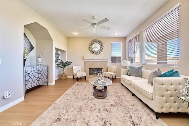 4224 Castlepeak Dr, Corona, CA 92883 - living room with a tiled fireplace, a ceiling fan, baseboards, and wood finished floors
