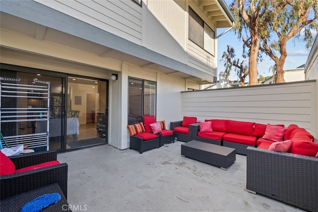 view of patio with an outdoor living space and fence