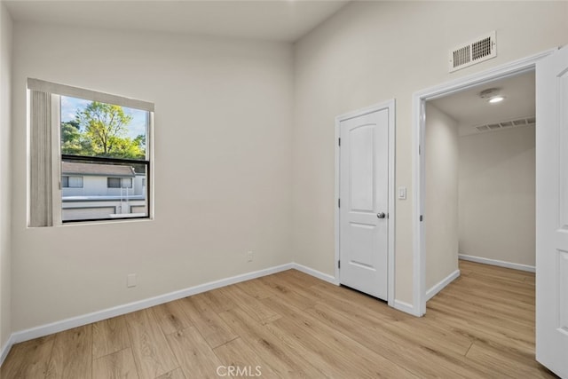 spare room with baseboards, visible vents, and light wood finished floors