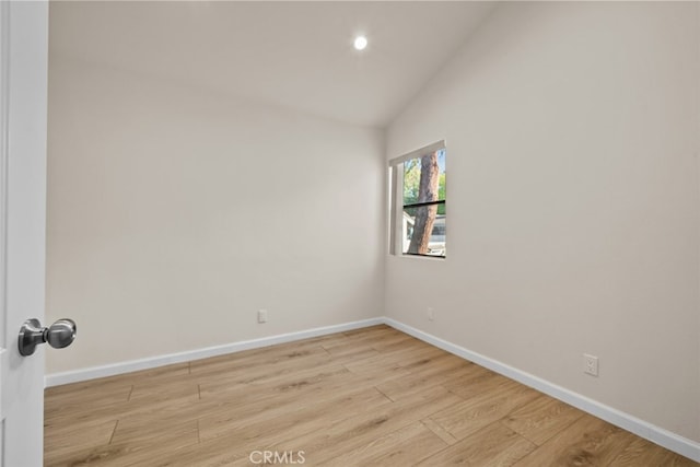unfurnished room featuring recessed lighting, baseboards, vaulted ceiling, and light wood finished floors