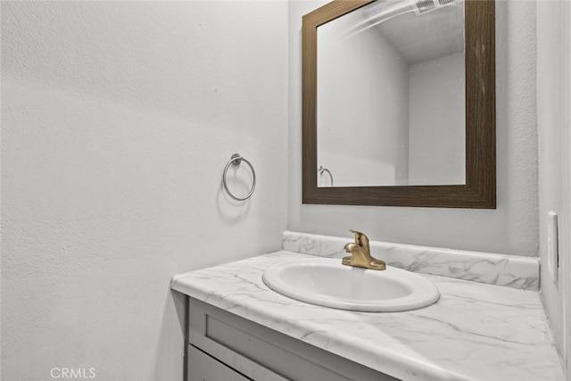 bathroom featuring vanity and a textured wall