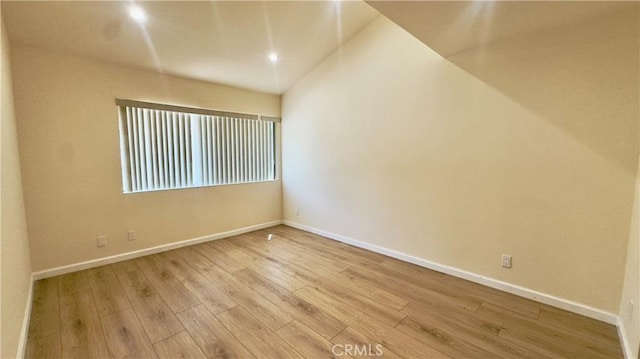 empty room with recessed lighting, baseboards, and wood finished floors