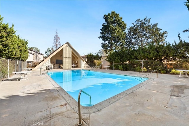 pool with a patio and fence