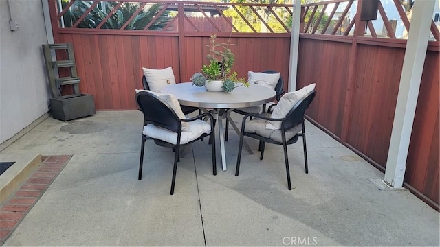 view of patio with outdoor dining space and a lanai