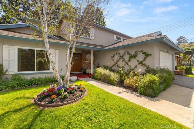 view of front of property featuring stucco siding, an attached garage, and a front yard