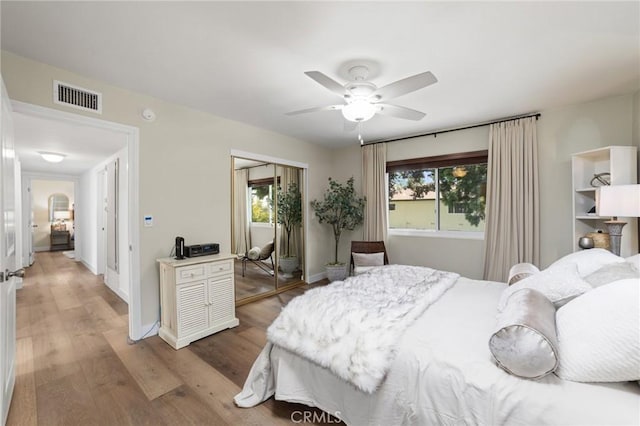 bedroom with light wood-style floors, a closet, multiple windows, and visible vents