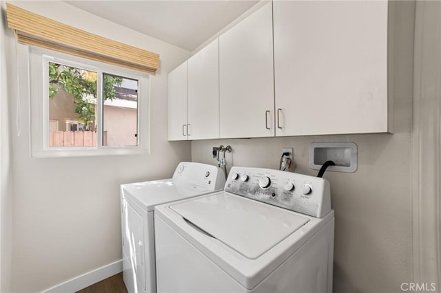 laundry area with washing machine and clothes dryer, baseboards, dark wood finished floors, and cabinet space