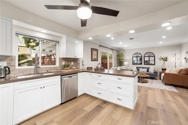 kitchen featuring light wood-type flooring, dark countertops, and stainless steel dishwasher