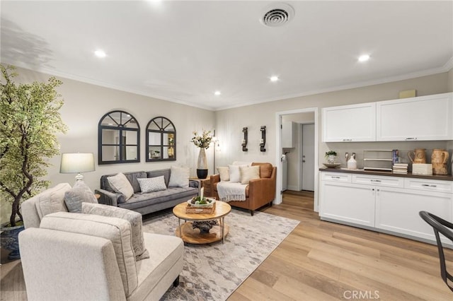 living room with light wood-style floors, recessed lighting, visible vents, and ornamental molding