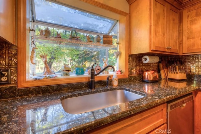 13730 Nimshew Rd, Magalia, CA 95954 - room details with brown cabinetry, dark stone counters, a sink, stainless steel dishwasher, and backsplash
