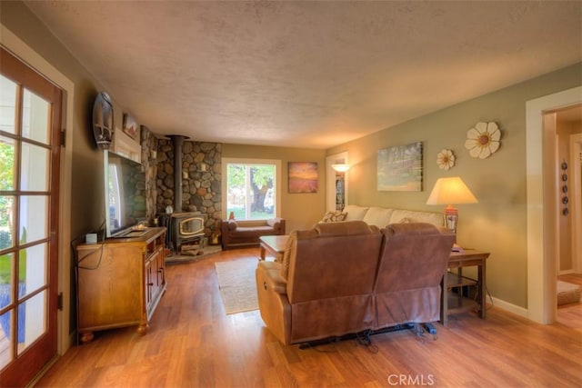 13730 Nimshew Rd, Magalia, CA 95954 - living area featuring a wood stove, wood finished floors, baseboards, and a textured ceiling