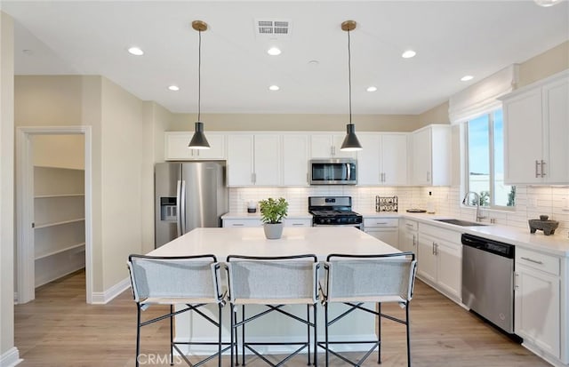 29754 Laurel Ct, Menifee, CA 92584 - kitchen featuring a breakfast bar area, a kitchen island, a sink, stainless steel appliances, and white cabinetry