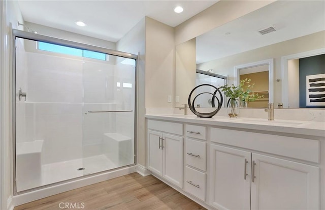 29754 Laurel Ct, Menifee, CA 92584 - bathroom with visible vents, double vanity, a stall shower, wood finished floors, and a sink