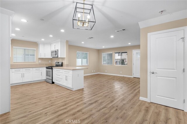 1109 N Mulberry, Compton, CA 90222 - kitchen featuring stainless steel appliances, a peninsula, open floor plan, white cabinetry, and recessed lighting