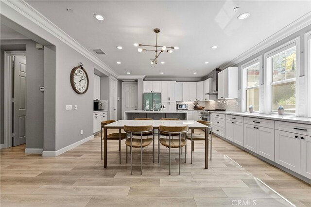 3905 Elderberry Cir, Corona, CA 92882 - kitchen featuring crown molding, a kitchen island with sink, tasteful backsplash, built in fridge, and a notable chandelier