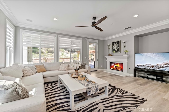 3905 Elderberry Cir, Corona, CA 92882 - living room featuring a glass covered fireplace, visible vents, light wood-style floors, ceiling fan, and ornamental molding