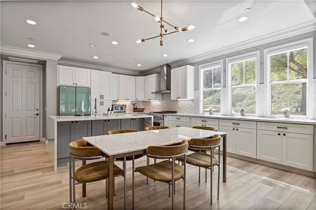 3905 Elderberry Cir, Corona, CA 92882 - kitchen with light wood-type flooring, tasteful backsplash, appliances with stainless steel finishes, and wall chimney exhaust hood