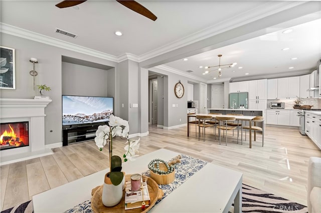 3905 Elderberry Cir, Corona, CA 92882 - living room with a ceiling fan, crown molding, light wood-style floors, and visible vents