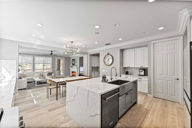 3905 Elderberry Cir, Corona, CA 92882 - kitchen featuring a sink, a ceiling fan, light wood finished floors, open floor plan, and decorative backsplash